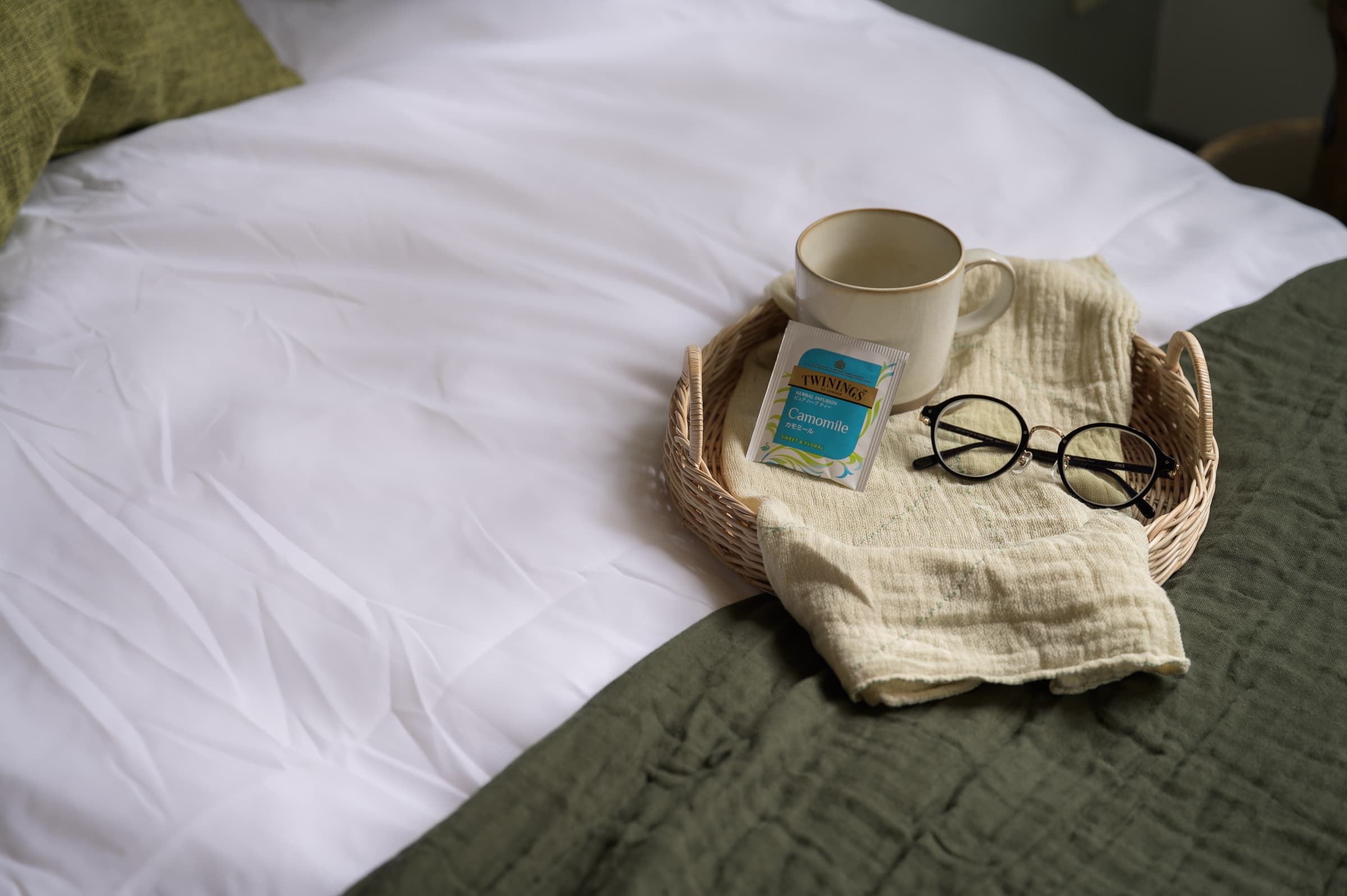 ベッドの上のカモミールティーと眼鏡 生活の痕跡と穏やかな光